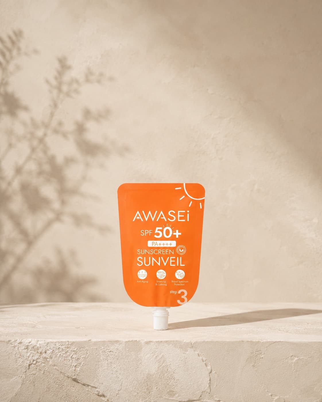 Awasei SUNVEIL SPF50+ sunscreen on an ivory stone pedestal in gentle sunlight